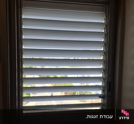 חלון עם תריסים סגורים בחדר